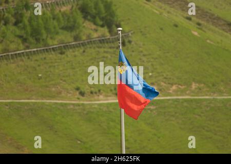 Sareis, Liechtenstein, June 20, 2021 Waving national flag on a mast in the alps Stock Photo