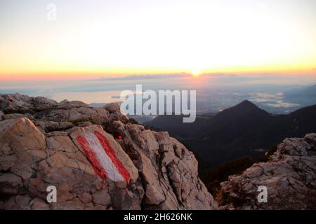 atmospheric sunrise,view from the summit of the kampenwand (1669 m) in chiemgau,path markings on the rocks,chiemsee,view over the sea of clouds,chiemgau alps,near aschau,upper bavaria,bavaria,southern germany,germany Stock Photo