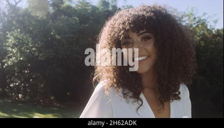 Smiling young latin afro woman. Joy, positive and love. Beautiful african-style hair Stock Photo