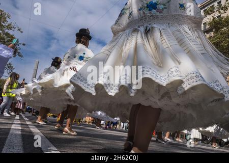 Close-up shot in motion from the low angle of a performance by a female group of Bolivian dancers wearing their traditional hats and costumes with wid Stock Photo