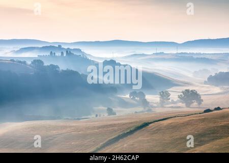 tuscan landscape,morning with fog in the valleys and rolling hills of the crete senesi,asciano,province of siena,tuscany,italy Stock Photo