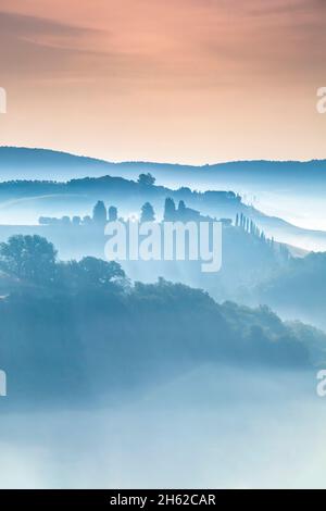 tuscan landscape,morning with fog in the valleys and rolling hills of the crete senesi,asciano,province of siena,tuscany,italy Stock Photo