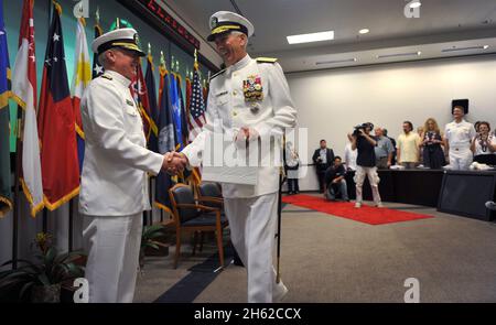 U.S. Navy Adm. Robert F. Willard, left, the outgoing commander of U.S. Pacific Command, shakes hands with incoming commander Adm. Samuel J. Locklear III during a change of command ceremony at the Nimitz-MacArthur Pacific Command Center at Camp H.M. Smith, Hawaii, March 9, 2012