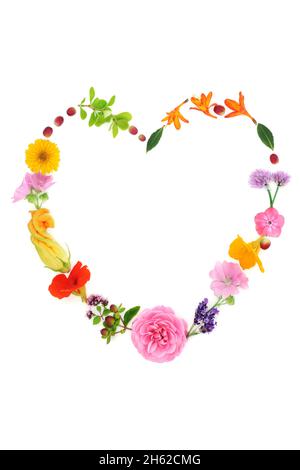 Heart shaped wreath of healing edible summer flowers and herbs. Used in natural herbal plant medicine, seasoning and food decoration purposes. Stock Photo