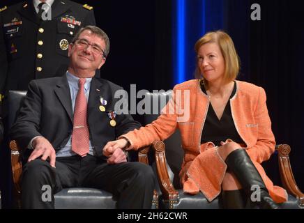 Deputy Secretary of Defense Ashton B. Carter and his wife Stephanie listen on stage as an Army musical unit delivers a tribute to him during a farewell ceremony held in the Pentagon Auditorium Dec. 2, 2013. Stock Photo