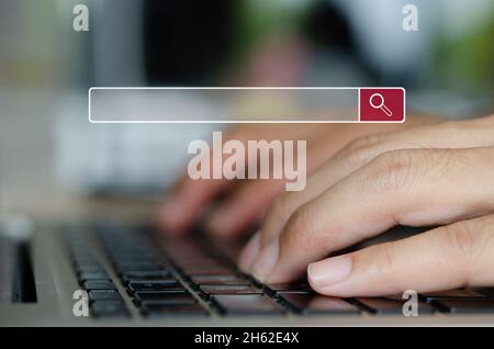 man hand is typing on a computer keyboard. Searching for information.Search the internet with an empty search bar, data information search bar.SEO net Stock Photo