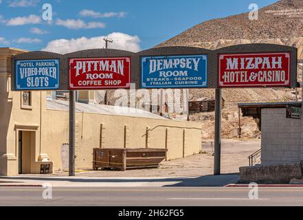Tonopah, Nevada, US - May 16, 2011: Downtown view, white on red or blue boards advertising offerings of Mizpah hotel and casino at its parking under b Stock Photo