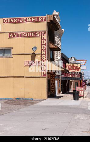 Tonopah, Nevada, US - May 16, 2011: dowtown main street. Antiques store the Hockshop beige-yellow side facade advertising guns and jewelry against blu Stock Photo