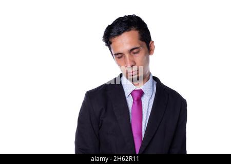 Latin entrepreneur falls asleep on his feet. Young adult wearing business suit. Lazy, very sleepy person isolated on all white background. Stock Photo