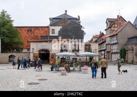 germany,saxony-anhalt,quedlinburg,tourists stand at a fountain on the kornmarkt,behind it you can see the kornmarkt 3 restaurant Stock Photo