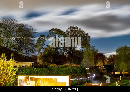 Sureal night time long exposure picture of Forest Holidays site, Forest of Dean. Moving clouds and vehicle light trails Stock Photo