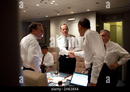 President Barack Obama shakes hands with Admiral Michael Mullen, chairman of the Joint Chiefs of Staff, aboard Air Force One en route to Washington, D.C., after delivering his Afghanistan speech at the U.S. Military Academy at West Point, Dec, 1, 2009 Stock Photo