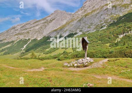 mountain cross on the saddle of the karwendelhaus,in the tyrolean karwendel mountains,left behind the eastern karwendelspitze,in the middle the grabenkarspitze,tyrol,austria,karwendel,mountain range Stock Photo