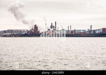 Waterfront steel mill on a cloudy autumn day. Pullution concept. Stock Photo