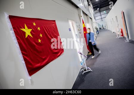 Glasgow, UK. 12th Nov, 2021. A woman walks into the Chinese delegation office at the UN Climate Change Conference COP26. The World Climate Conference is taking place in Glasgow. Around 200 countries are negotiating how to curb the global climate crisis and global warming. Credit: Christoph Soeder/dpa/Alamy Live News Stock Photo