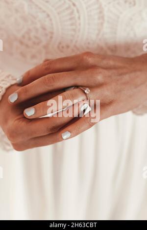 bride puts engagement ring on her finger Stock Photo