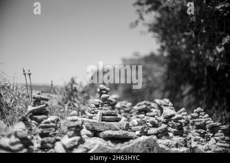 pyramids of stones and pieces of ceramics as a symbol of harmony,balance,peace of mind under the walls of the city of ronda,andalusia,spainagainst the backdrop of mountains. Stock Photo