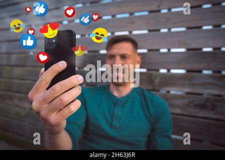 Vlogger streaming a live video. Happy man using smartphone with social media or live stream Stock Photo