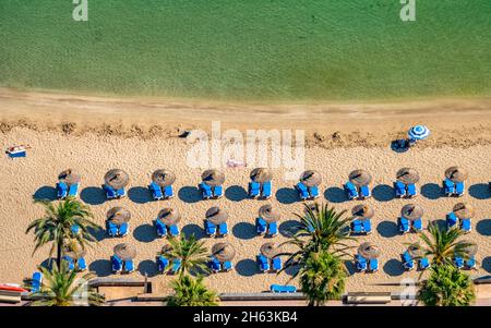 aerial view,sunbathing on the beach,straw parasols and deck chairs,playas de sóller,sóller,mallorca,balearic islands,spain Stock Photo