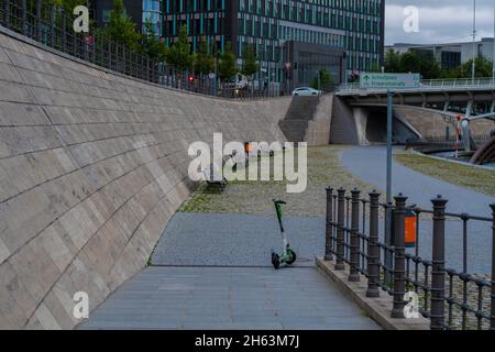 germany,berlin,august 17,2021,incorrectly parked e-scooter on a sidewalk in the early morning in berlin on the banks of the spree,unsightly sight in berlin's city center,big problem in berlin Stock Photo