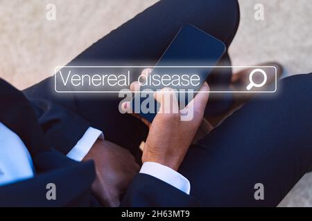 Man with urology problems searching in internet about venereal disease Stock Photo