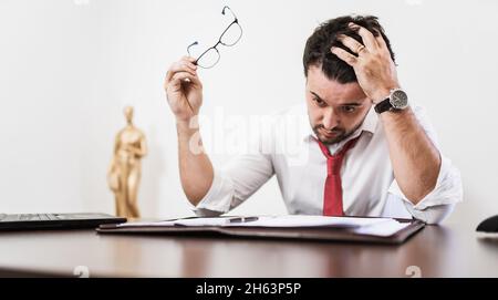 Young Latin male lawyer or employee working night in the office Stock Photo