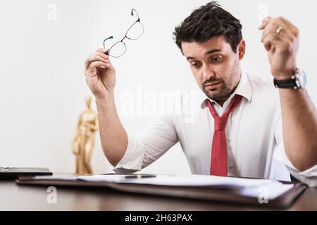 Young Latin male lawyer or employee working night in the office Stock Photo