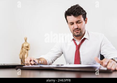 Young Latin male lawyer or employee working night in the office Stock Photo