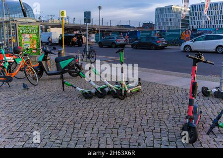 germany,berlin,carelessly parked and overturned e-scooters in front of the main train station in berlin in the early morning Stock Photo