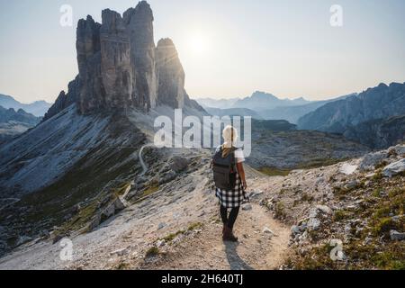 women hiker with backpack enjoying the tre cime di lavaredo during sunset. dolomites,italy. Stock Photo