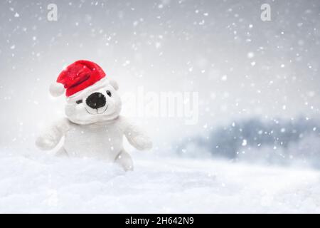 little polar bear made of plush in the snow Stock Photo