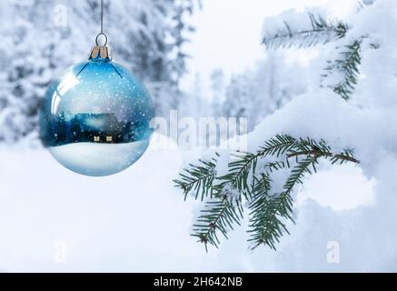 christmas ball with a winter landscape in front of a blurred snowy background Stock Photo