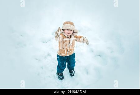 Winter child happy in snow outdoor. Cute boy in winter clothes. Theme Christmas holidays and New Year. Stock Photo
