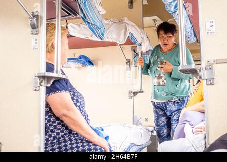 Passengers in the 3 class car, platzcart carriage in the train operated ...