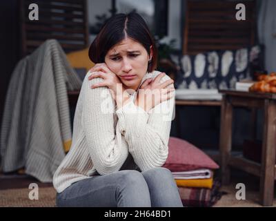 Young depressed asian woman sitting on porch of backyard. She feeling sad and worried suffering depression in mental health. Mental health, anxiety de Stock Photo