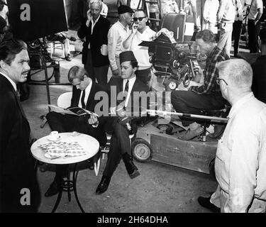 MICHAEL STRONG DAVID McCALLUM as Illya Kuryakin and ROBERT VAUGHN as Napoleon Solo on set candid with Camera / Movie Crew during filming of THE DEADLY GODDESS AFFAIR 1966 (Season  2 Episode 17) director SEYMOUR ROBBIE of THE MAN FROM U.N.C.L.E. US TV Series 1964 - 1968) creator Sam Rolfe Arena Productions / MGM Television Stock Photo