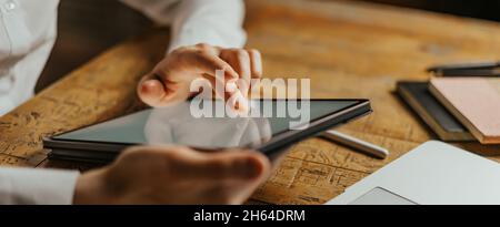 Close up photo of male hands tapping on digital tablet screen. Stock Photo