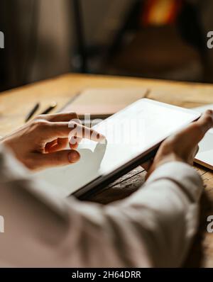 Close up photo of male hands tapping on digital tablet screen. Stock Photo