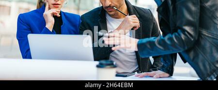 Group of corporate colleagues working together outdoors. Modern business professionals having a discussion during coffee break. Stock Photo
