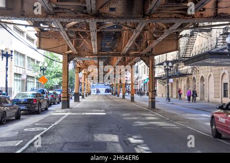 Chicago, IL, USA-September 2019; View of one of the city streets seen from underneath the elevated train tracks of the Chicago L Stock Photo