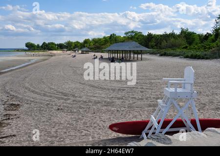 Old Greenwich, CT, USA-August 2020: View over the beach of Greenwich Point Park or Tods Point with life save chair in front with board Stock Photo