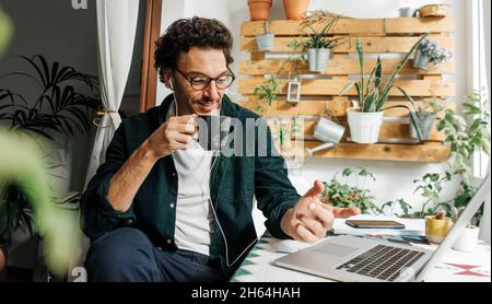 Man with laptop working remotely from home. Freelancer at remote work. Cozy workplace Stock Photo