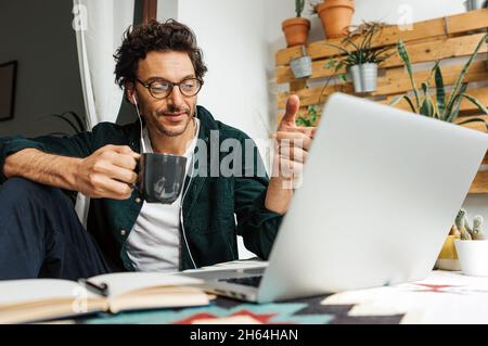 Man with laptop working remotely from home. Freelancer at remote work. Cozy workplace Stock Photo