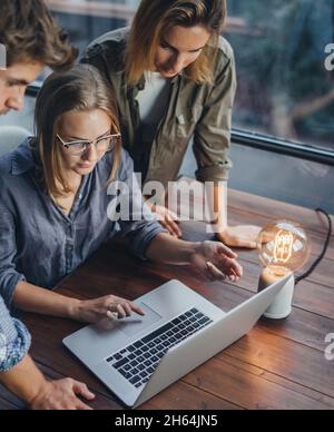 Group of young colleagues using laptop. People working or studying together. Business team in office. Teamwork. Startup concept Stock Photo