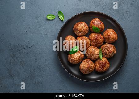 Fried meatballs in a black plate on a graphite background. Top view, copy space. Stock Photo