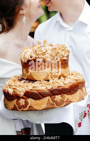 Charming wedding couple holding their wedding cake close up Stock Photo