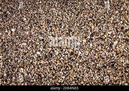 Background of multicolored sea pebbles on the beach. Small color wet stones gravel texture background. Stock Photo