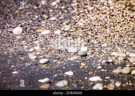 Background of multicolored sea pebbles on the beach. Small color wet stones gravel texture background. Stock Photo