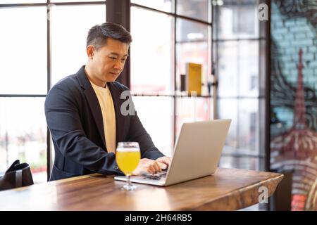 Man working on laptop in bar Stock Photo