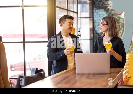 Friends talk and drink beer in bar Stock Photo
